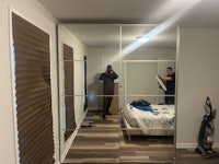 a man is standing in front of a mirror in a bedroom